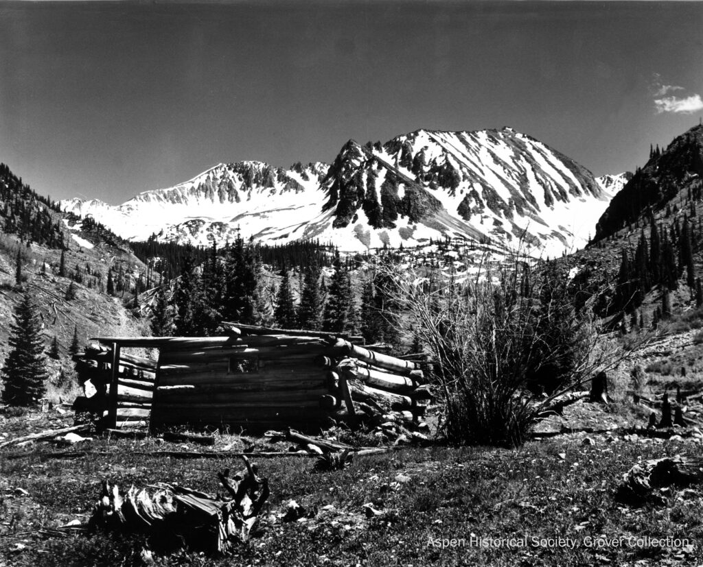 One sepia-toned photograph of the remains of a cabin at what was known to be "Cooper Camp,"